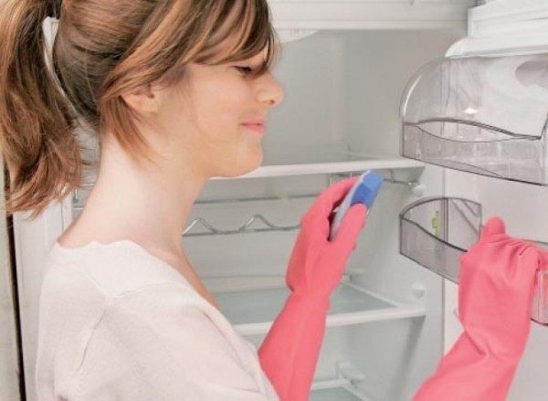 Girl washes the fridge