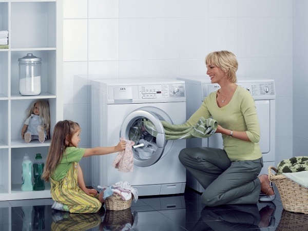 Mother and daughter near the washing machine
