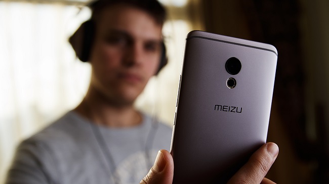 A young man makes a photo camera of a smartphone